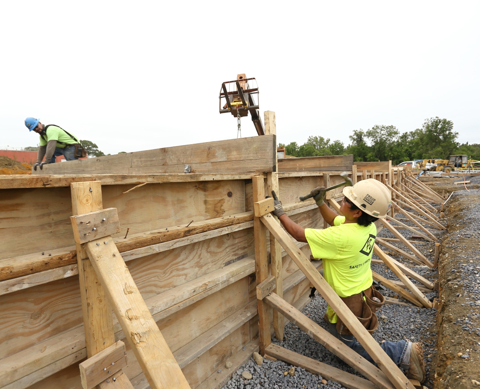 Construction worker hammering and building a wall